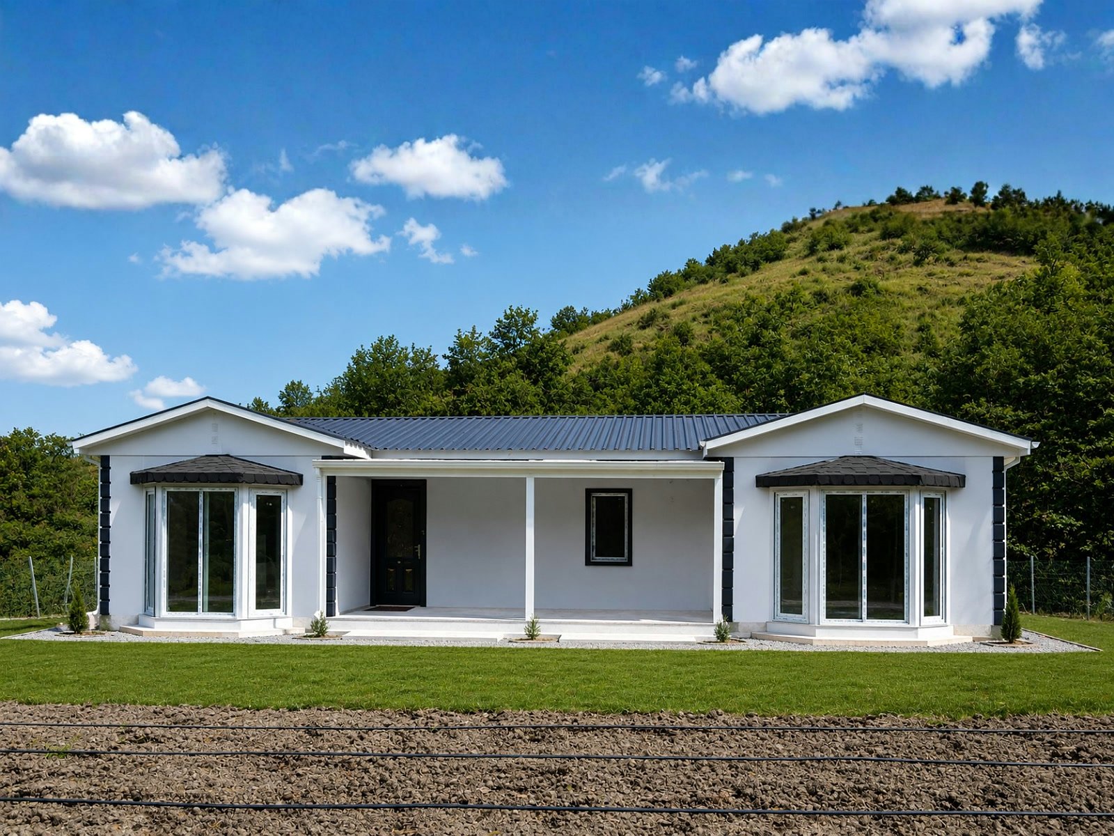 Tek katlı 4+1 prefabrik ev, beyaz cephe ve siyah pencere çerçeveli geniş veranda girişli dış görünüm